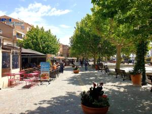 ulica miejska ze stołami, krzesłami i drzewami w obiekcie Studio calme avec coin nuit, terrasse et parking - Proche plage et commerces - FR-1-251-420 w mieście Le Lavandou +7 zdjęć