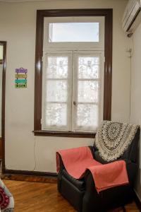 a living room with a window and a black leather chair at Calido alojamiento en San Telmo EH in Buenos Aires