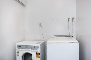 eine Waschmaschine und eine Waschmaschine im Zimmer in der Unterkunft Self Contained Cottage Pukekohe in Auckland