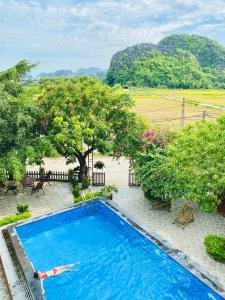 a person swimming in a swimming pool in a resort at Tam Coc Sunshine Homestay in Ninh Binh