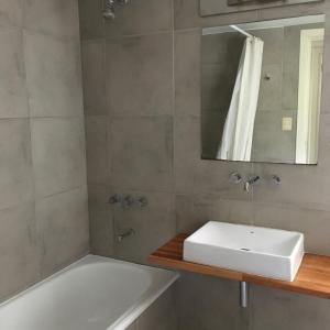 a bathroom with a sink and a tub and a mirror at Casa Balcón del Golf in Sierra de los Padres