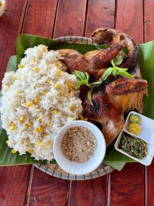 um prato de comida com arroz e uma galinha em Little Rock Homestay em Phong Nha