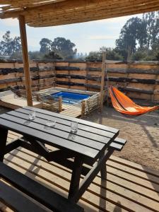 a picnic table and a hammock on a deck at Eco Parcela La Chacra in Catapilco
