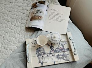 - un livre et une tasse de café sur un lit dans l'établissement The little cottage, à Tauranga