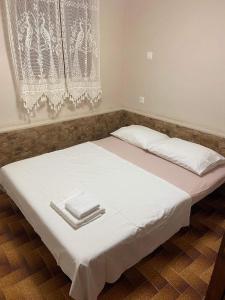 a bed with white sheets and napkins on it at Your Holiday House in Porto Rafti