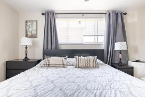 a bedroom with a large white bed with two lamps at Georgetown Villas 2-1c King and Queen Bedrooms ideal for long stays! in Fairview Park