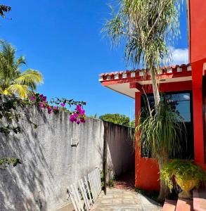 a red house with a fence and a white chair at Casa Siloe in Campeche