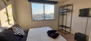 1 dormitorio con cama y ventana grande en Studio - O seu melhor lugar no Brás 200 Mts Metrô en São Paulo