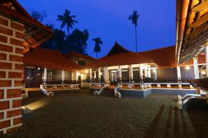 a row of benches in front of a building at night at Palmy Lake Resort in Alleppey