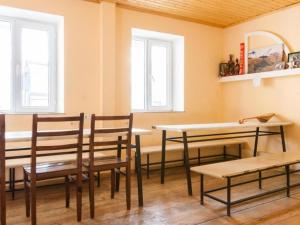 a room with chairs and a table and two windows at Veriko's Guest Hause in Kazbegi