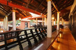 a building with columns and chairs in a room at Palmy Lake Resort in Alleppey