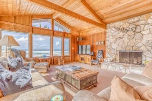 a living room with a large stone fireplace at Nestle Inn - Meredith Lodging in Neskowin