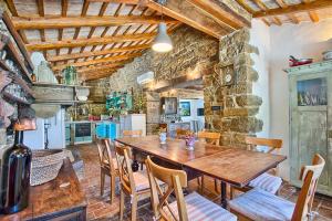 kuchnia i jadalnia z drewnianym stołem i krzesłami w obiekcie Villa Sancta Maria w mieście Motovun