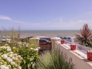 een uitzicht op de oceaan vanuit een huis met een hek bij 6 Gloster Terrace in Folkestone