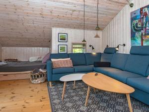 Holiday home Silkeborg XIX في سيلكبورج: غرفة معيشة مع أريكة زرقاء وطاولة