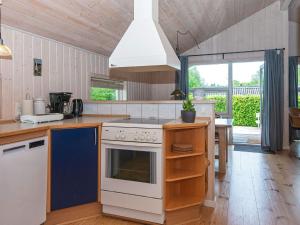 eine Küche mit einem Herd oberer Ofen neben einem Tisch in der Unterkunft Holiday home Silkeborg XIX in Silkeborg