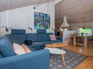 Holiday home Silkeborg XIX في سيلكبورج: غرفة معيشة مع أريكة زرقاء وطاولة