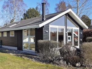 Holiday home Præstø V في براستو: منزل أسود صغير مع نافذة كبيرة