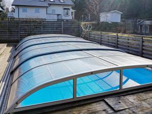um telhado de vidro sobre uma piscina numa casa em Holiday home TROSA em Trosa