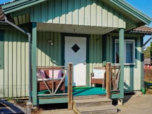 Casa verde con porche y cama en Holiday home TROSA en Trosa