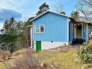 una casa azul y blanca en la cima de una colina en Holiday home TYRESÖ V en Tyresö