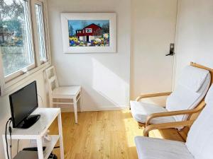 sala de estar con escritorio, TV y silla en Holiday home TYRESÖ V en Tyresö