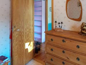 a room with a wooden dresser and a mirror at Holiday home NORRTÄLJE IX in Norrtälje