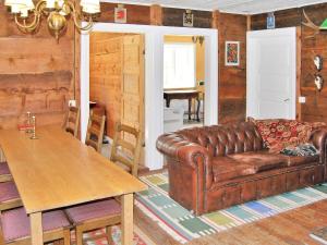 a living room with a leather couch and a table at Holiday home VANKIVA in Vankiva