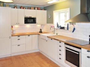 a kitchen with white cabinets and a counter top at Holiday home VANKIVA in Vankiva