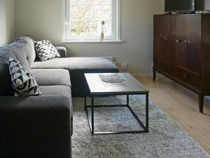 sala de estar con sofá y mesa de centro en Holiday home SÖLVESBORG XVI, en Sölvesborg