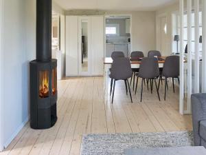 sala de estar con chimenea y mesa con sillas en Holiday home SÖLVESBORG XVI, en Sölvesborg