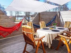 - une table et des chaises sur une terrasse avec un hamac dans l'établissement Holiday home HOVMANTORP II, à Hovmantorp