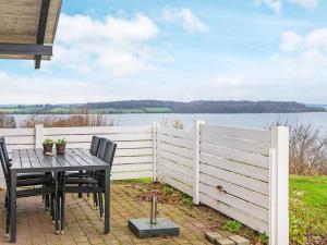 una mesa y sillas en un patio con una valla en Panoramic Seaside Escape - By Traum Ferienwohnungen, en Aabenraa