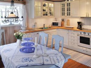 uma cozinha com uma mesa com uma toalha de mesa azul e branca em Holiday home HÖLLVIKEN III em Höllviken
