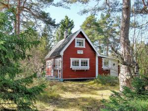 uma casa vermelha no meio da floresta em Holiday home HÖLLVIKEN III em Höllviken