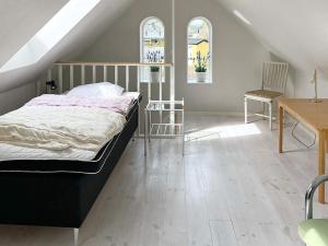 Yngsjöにある6 person holiday home in YNGSJÖ, SVERIGE-By Traumのベッドとテーブルと2つの窓がある寝室