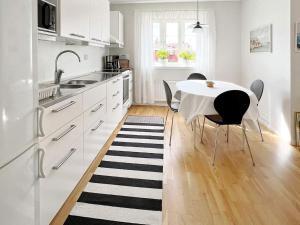 YngsjöにあるHoliday home YNGSJÖ, SVERIGE IIの白いキッチン(テーブル、椅子付)