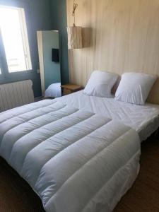 a large white bed in a bedroom with a window at Le Galion -1er Ligne Vue Mer Classe3*+parking in Canet-en-Roussillon