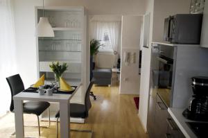 cocina y sala de estar con mesa y sillas en Bort Lodging, en Willich