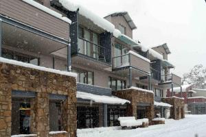 a snow covered building with snow on the ground at Squatters Run Apartments in Thredbo
