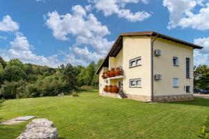 a house with a large yard in front of it at Selak Apartments in Grabovac