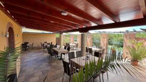a restaurant with tables and chairs in a patio at Patyi Étterem és Hotel in Bögöte