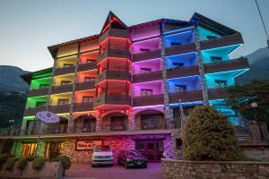 un bâtiment avec des lumières colorées sur son côté dans l'établissement Relais Du Foyer, à Châtillon