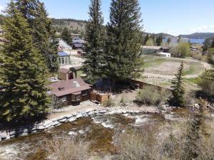 an aerial view of a house with trees and a river at Thorpe On The Water. Creekside Nederland Cabin. in Nederland