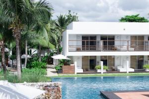a villa with a swimming pool in front of a house at Putahracsa Hua Hin in Hua Hin