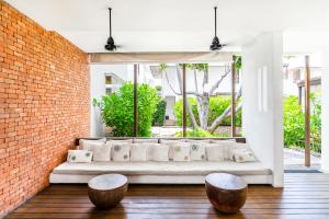 a living room with a white couch and two stools at Putahracsa Hua Hin in Hua Hin