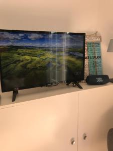 a flat screen tv sitting on top of a cabinet at Etoile aan Zee in Vrouwenpolder