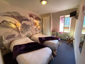 a room with three beds with a mural on the wall at Auberge Saint Fleuret in Estaing