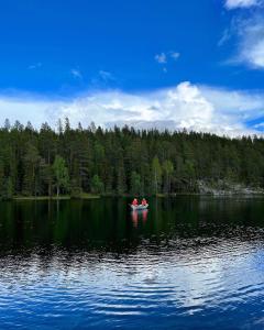 duas pessoas num barco num grande lago em Holiday Home Ruka Lammensyli em Ruka