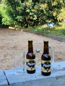 two bottles of beer sitting on a table with a glass at F2 avec jacuzzi, pétanque, à 3 min mer, dans grande propriété in Porticcio